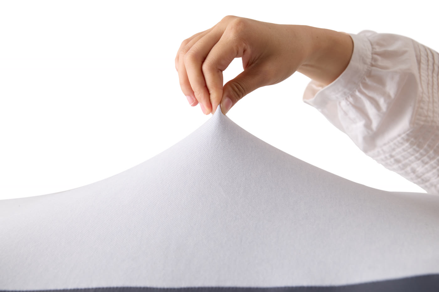 The breathable performance-fabric cover being lifted from the pillow